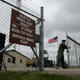 In this photo taken June 24, 2014, Capt. Robby Modad closes the gate at an ICBM launch control facility in the countryside outside Minot, N.D. Launch control officers working from a secure capsule far underground the complex control 10 Minuteman 3 missiles carrying nuclear warheads spread out in the fields around the facility. (AP Photo/Charlie Riedel)